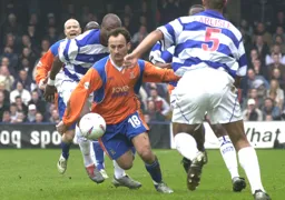 Clarke Carlisle tries to halts Ahmet Brkovic from getting through
