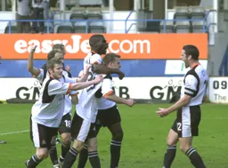 Keith Keane is mobbed by his team mates after scoring a last minute winner