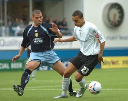 Dean Morgan shields the ball from a Leeds player