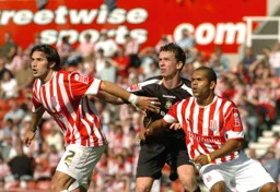 Kevin Foley waits for the ball challenged by two Stoke players