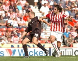 Warren Feeney tries to control the ball under pressure from a Stoke player