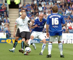 Kevin Nicholls passes whilst being challenged by a Leicester player