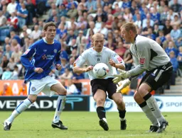 Warren Feeney closes in as the Leicester goalkeeper catches the ball
