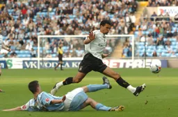 Carlos Edwards hurdles a sliding Coventry tackle