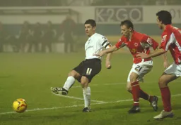 Stephen Robinson slides the ball past Crewe players