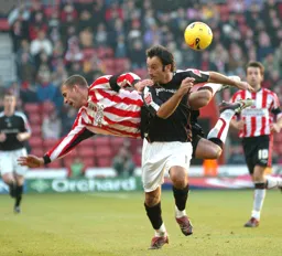 Ahmet Brkovic comes away with the ball from a high tackling Southampton player