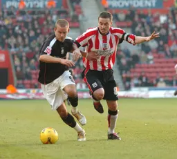 Rowan Vine comes away with the ball challenged by a Southampton player