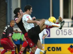 Chris Coyne and a Stoke player try to win the ball