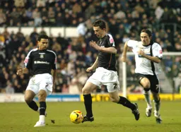 Kevin Foley moves forward with the ball as Carlos Edwards watches on