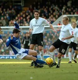 Warren Feeney jinks the ball past a Ipswich player watched on by Chris Coyne