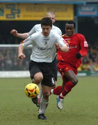 Stephen Robinson comes away with the ball pursued by a Watford player