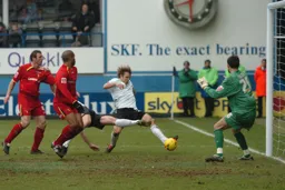 Penalty box action. Marcus Heikkinen stretches to kick the ball towards goal