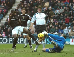 Leon Barnett tries to dink the ball over the Preston goalkeeper watched by Steven Howard