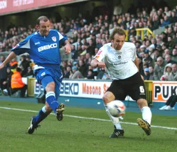 Paul Underwood crosses the ball under pressure from a Millwall player