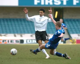 Carlos Edwards evades a sliding tackle from a Millwall player