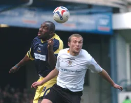Warren Feeney goes up for a header with a Derby defender