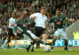 Steven Howard tries to break through as two Plymouth players challenge
