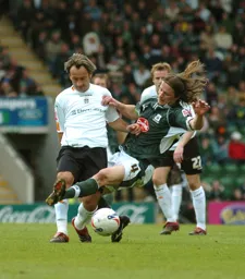 Ahmet Brkovic passes the ball whilst being challenged by a high tackle