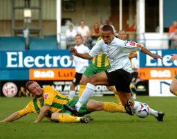 An outstretched boot nicks the ball off Dean Morgan