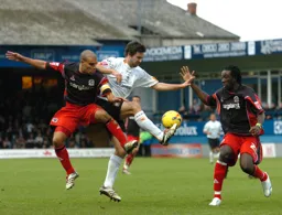 Adam Boyd gets between Marcus Bignot and Damion Stewart to win the ball