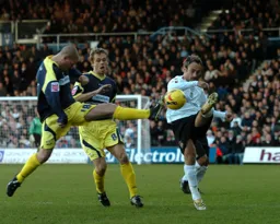 Seth Johnson tries to block Ahmet Brkovic from clearing the ball