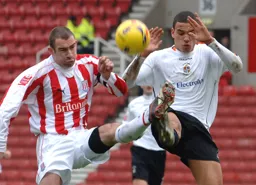 Dean Morgan and Danny Higginbotham challenge for the ball