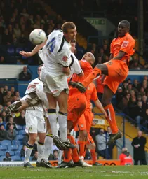 Leon Barnett heads the ball towards goal