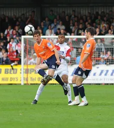 George Pilkington heads the ball clear