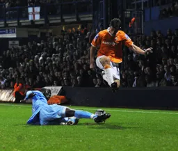A York defender wins the ball as Tom Craddock leaps over him