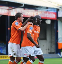 Steve Basham and Claude Gnakpa celebrate with Adam Newton after he scored the second goal