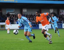 Adam Newton in a race for the ball with Cam Mawer