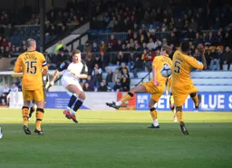 Kevin Gallen sees his goalbound shot blocked by Brian Saah