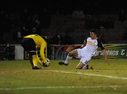 Michael Ingham gathers the ball as Tom Craddock slides in