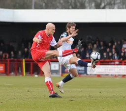 Raised boots go in as Rossi Jarvis and Eddie Hutchinson fight for the ball