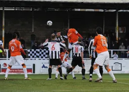 Claude Gnapka rises above the defence wearing a pair of gloves from the club shop