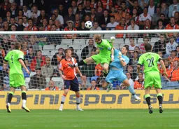 Mark Tyler punches the ball clear under pressure from James Walshaw