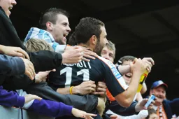 Robbie Willmott celebrates with some travelling Hatters fans after scoring his second goal