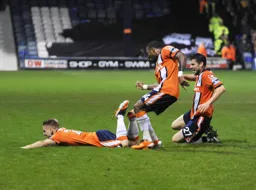 Adam Watkins slide to the ground to celebrate his goal