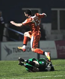 The keeper gathers the ball as Stuart Fleetwood leaps over him