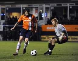 Craig McAllister rounds Tom McNeil before slotting the ball into the net for Town`s third goal