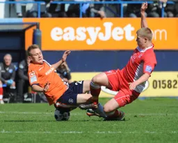 Adam Watkins goes in for a midfield tackle