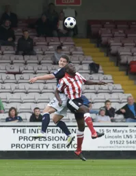 Simon Ainge rises highest to head the ball clear
