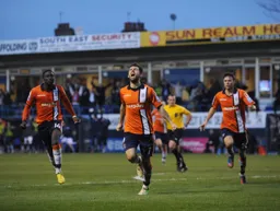 Arnaud Mendy and Jonathan Smith run to join Alex Lawless as he celebrates his goal