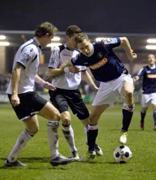 Dave Martin takes on two defenders