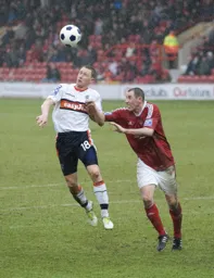 Dave Martin wins a header in front of Stephen Wright