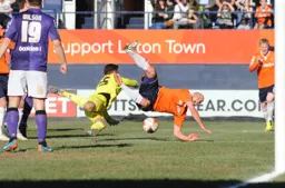 Luke Guttridge appears to be sent flying by the keeper