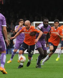 Luke Guttridge forces his way through in midfield