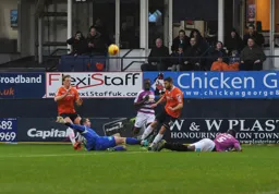 Barnet keeper Jamie Stephens dives in feet first to block Josh McQuoid