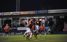 Zander Diamond heads the ball away from an onrushing Luke Wilkinson