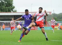 Dean Wells toe ends the ball away from Isaac Vassell